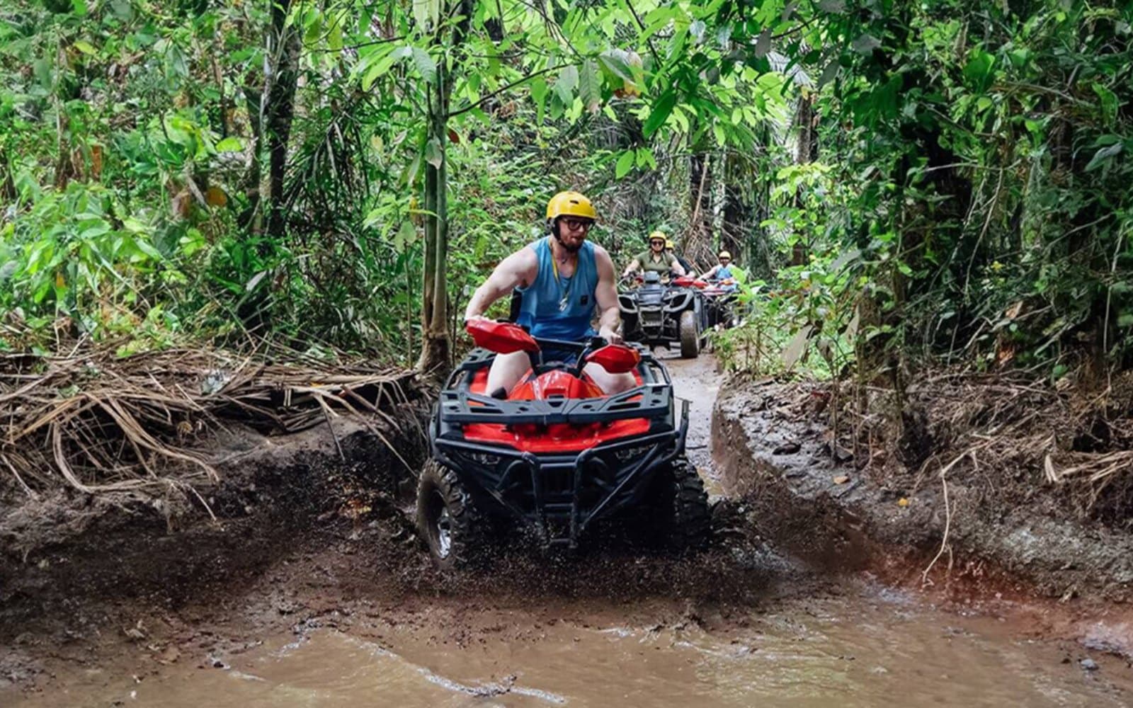 Conquer wet and muddy off-road tracks surrounded by natural stone cliffs and lush surroundings.