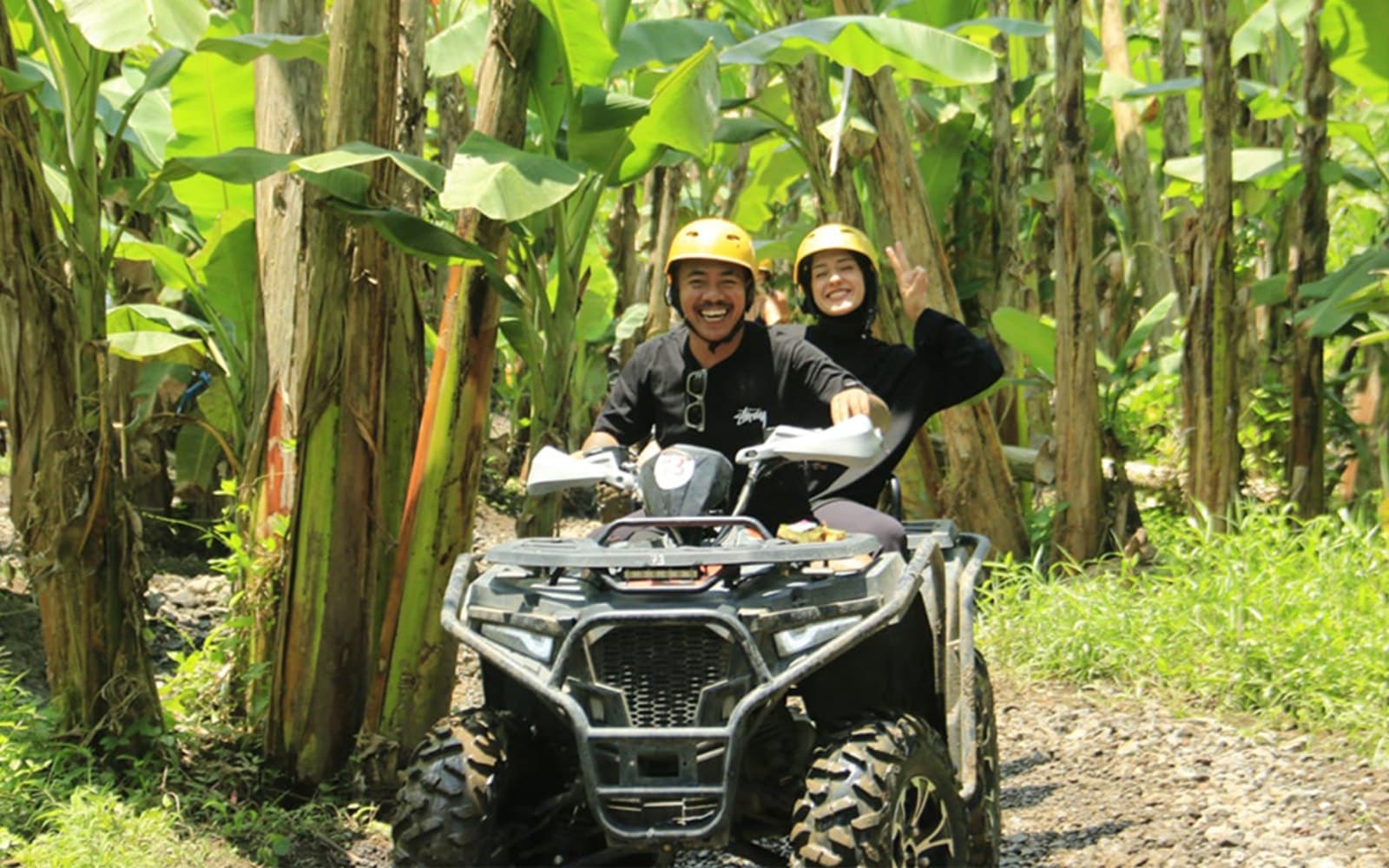 Powering through wet, muddy off-road terrain surrounded by lush tropical greenery.